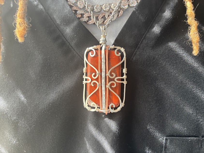 Custom wire-wrapped red jasper pendant in a silver-plated cage design